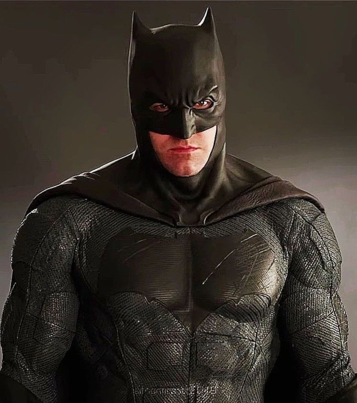 a man in a batman costume standing with his hands on his hips