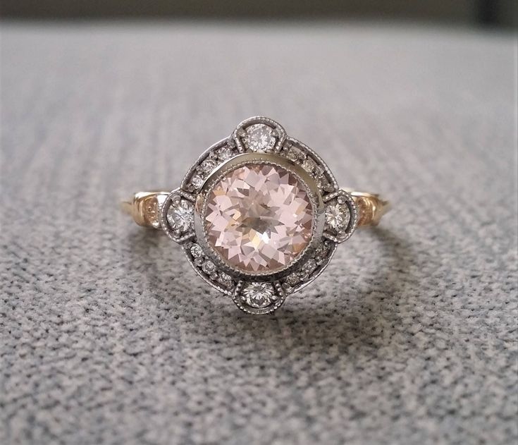 a pink diamond ring sitting on top of a gray carpeted floor next to a window