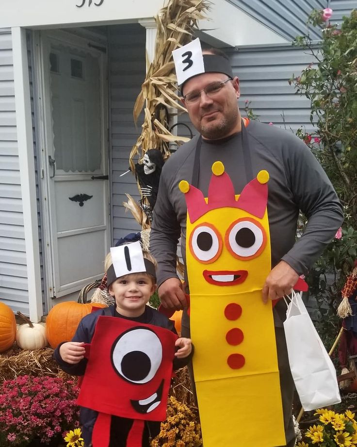 a man standing next to a little boy in a costume