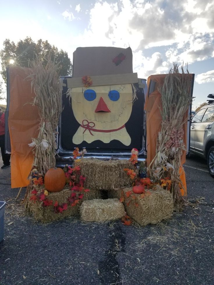 an outdoor display with hay bales, pumpkins and scarecrow heads on it