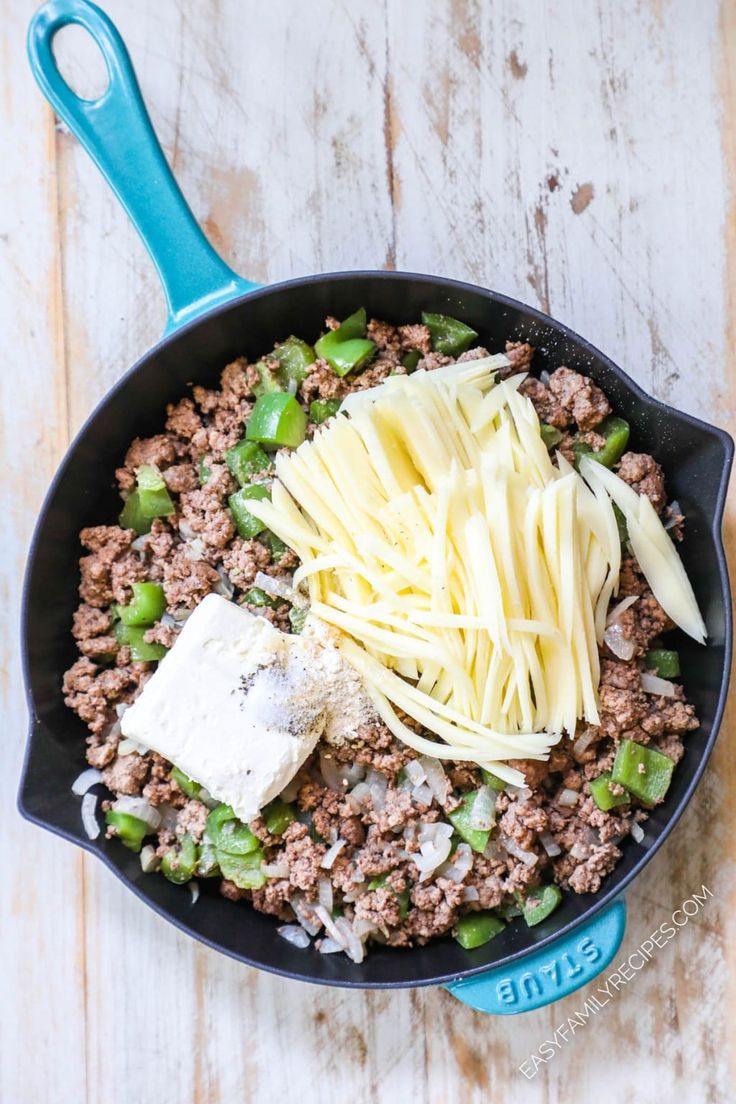 a skillet filled with ground beef and cheese