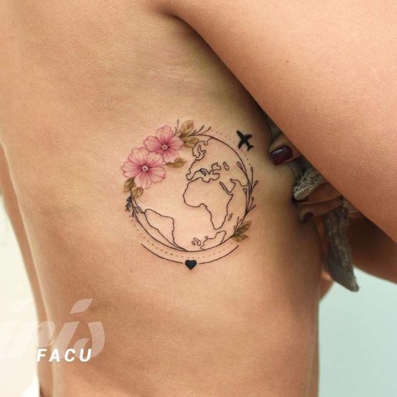 a woman's stomach with a tattoo on it that has flowers and an airplane flying over the earth