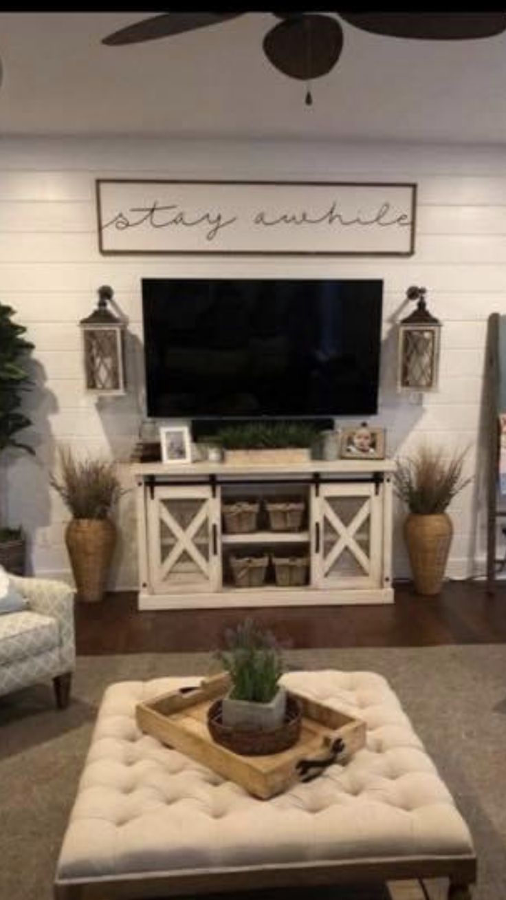 a living room filled with furniture and a flat screen tv mounted to the wall above it