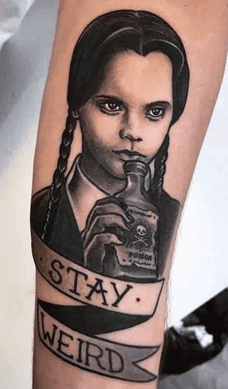 a person with a tattoo on their arm holding a camera and the words stay weird