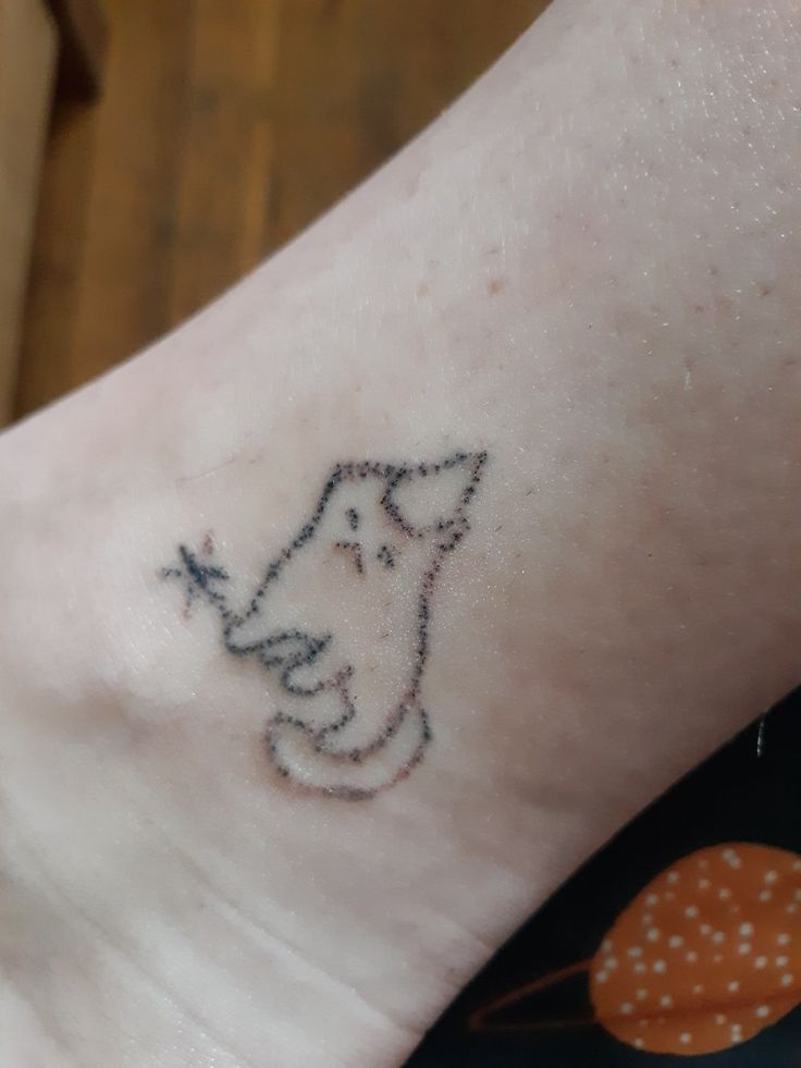 a small cat tattoo on the ankle