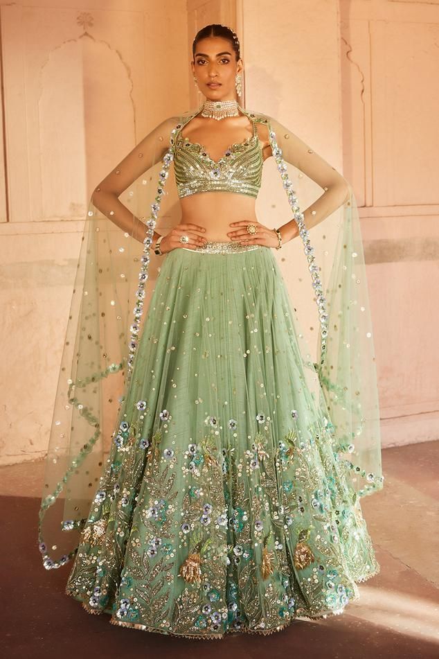 Light green attached cancan lehenga with floral applique, sequin, zardozi, bead, thread embroidery. Paired with stripe embroidered blouse and dupatta.
Components: 3
Pattern: Embroidery
Type Of Work: Floral applique, sequin, zardozi, bead, thread
Neckline: Sweetheart neck
Sleeve Type: Sleeveless
Fabric: Blouse and Lehenga: Silk, Net, Dupatta: Net
Color: Green
Other Details: 
Lehenga Length: 44 inches
Back tassel tie-up
Note: Necklace worn by the model is not for sale
Occasion: Bride - Aza Fashion Indian Wedding Dress Traditional, Lehenga Silk, Guest Ideas, Baju Kahwin, Embroidered Birds, Asian Clothing, Green Lehenga, Muted Green, Vacuum Storage