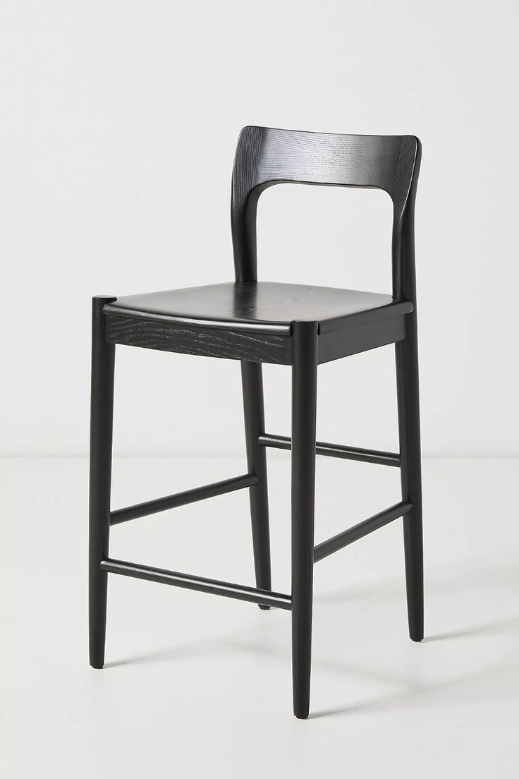 a black wooden chair sitting on top of a white floor