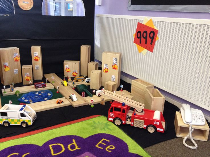 there is a play area with toys on the floor and in front of some cardboard boxes