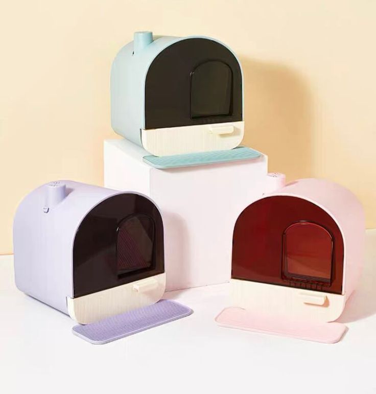 three different colored mailboxes sitting next to each other on a white counter top