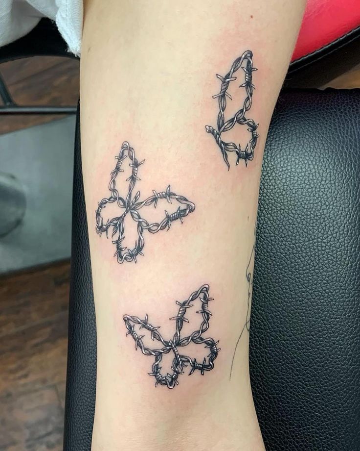 the tattoo on the leg shows three butterflies, one is black and one is white