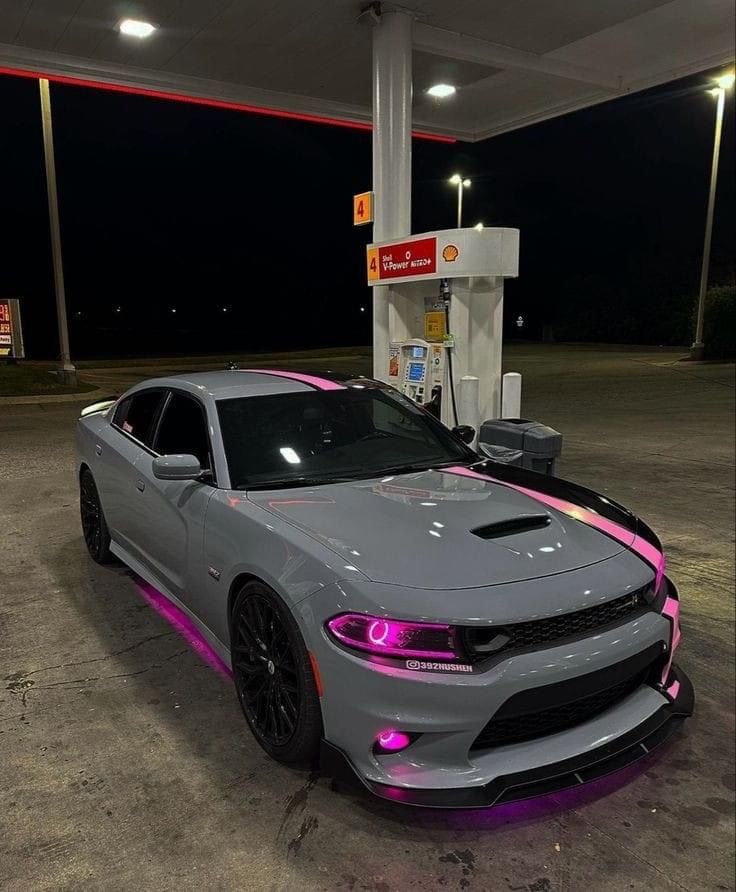 a gray and pink car parked at a gas station