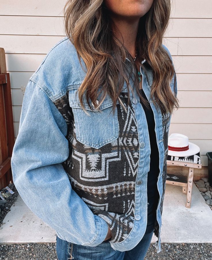 The Denim Aztec Jacket is the perfect addition to your fall wardrobe! This stylish button-up jacket features a beautiful Aztec pattern on the front and back, while the shoulders and sleeves remain classic denim. Whether you pair it with a cozy hoodie and sneakers for a casual day out, or dress it up with jeans and boots for a night out, this jacket is versatile and chic. A must-have piece for the season! Stefanie is wearing a size XL. Fit: Slightly oversized. Jean Jacket Winter Outfits, Western Granola Outfits, Denim Western Outfit, Granola Western, Western Jackets, Aztec Jacket, Western Fits, Western Wear Outfits, Western Style Outfits