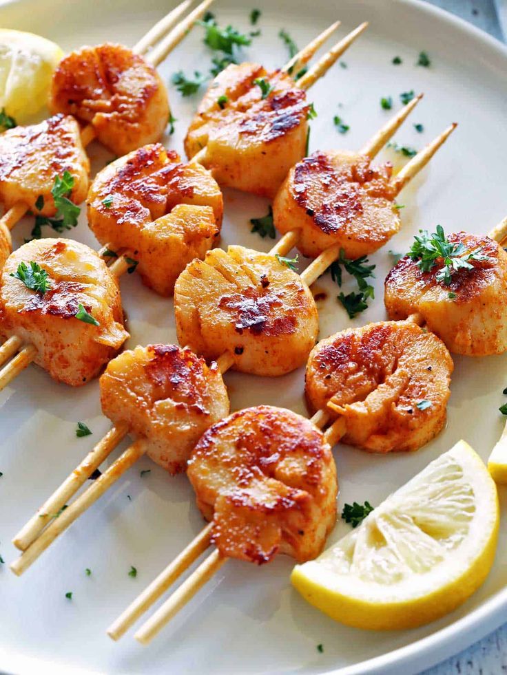 shrimp skewers with lemon wedges and parsley garnish on a white plate