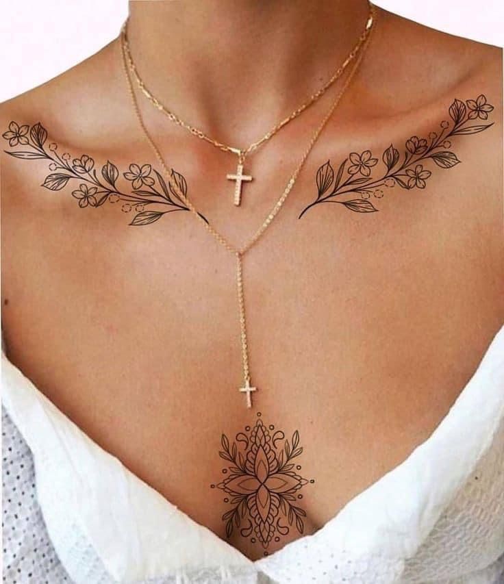 a woman's chest with a cross and flower tattoo on the top of it