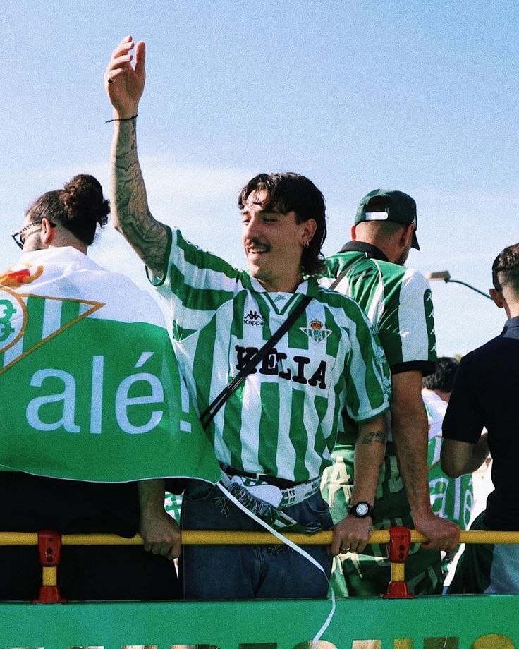 a group of men standing next to each other in front of a green and white sign