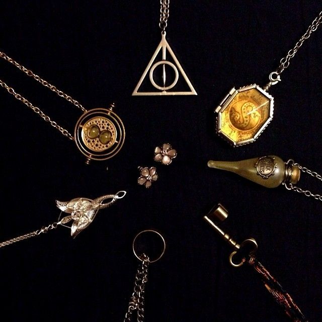 a collection of harry potter necklaces on a black background with gold and silver charms