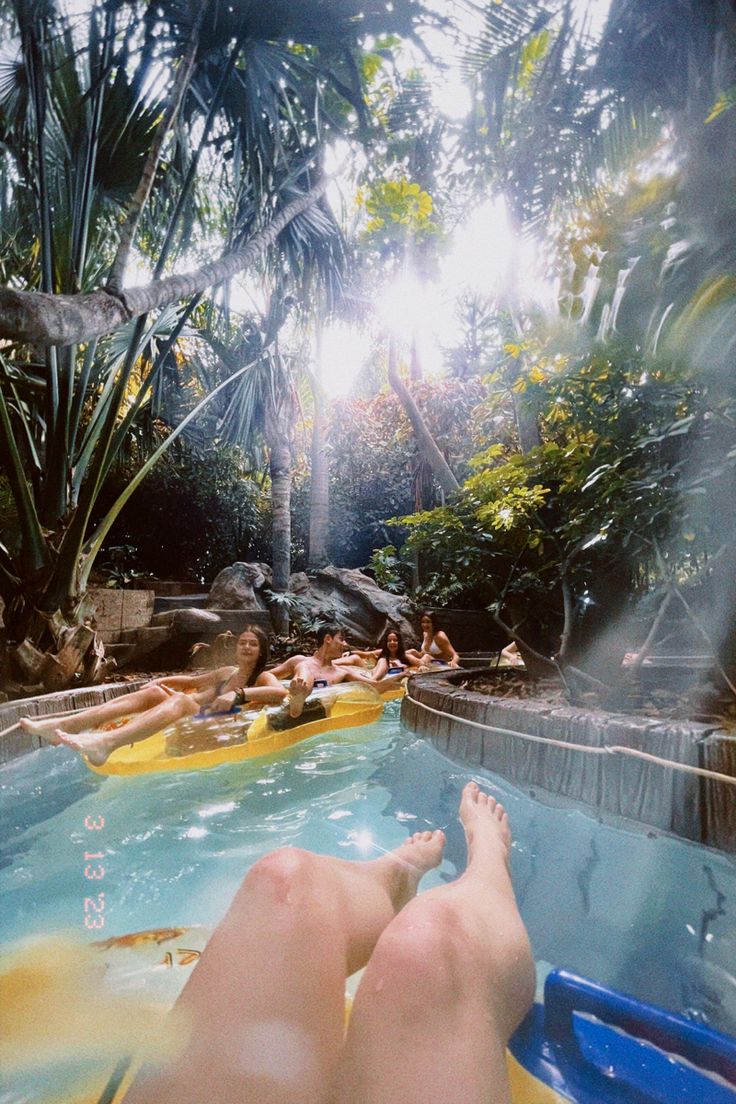 people are relaxing in the pool with their feet on the water and one person is laying down