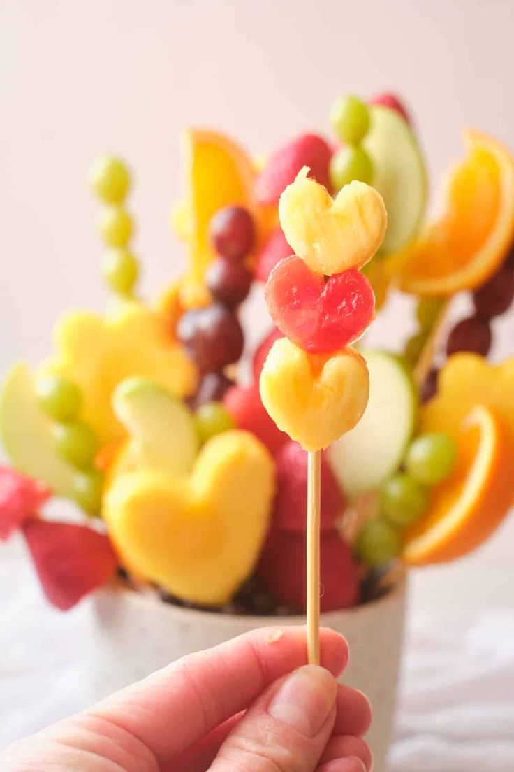 a person is holding a fruit skewer in their hand