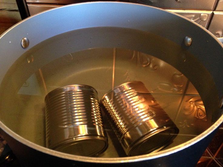 two tin cans sitting in a pot on the stove