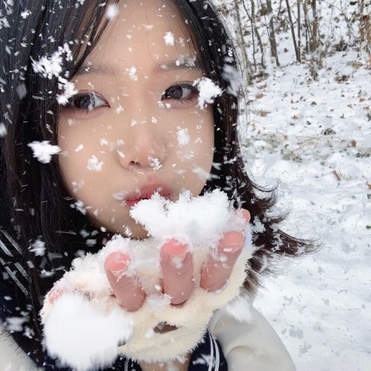 a woman is blowing snow on her fingers