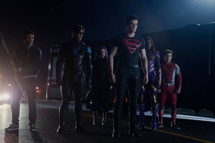 a group of young men standing in the street at night