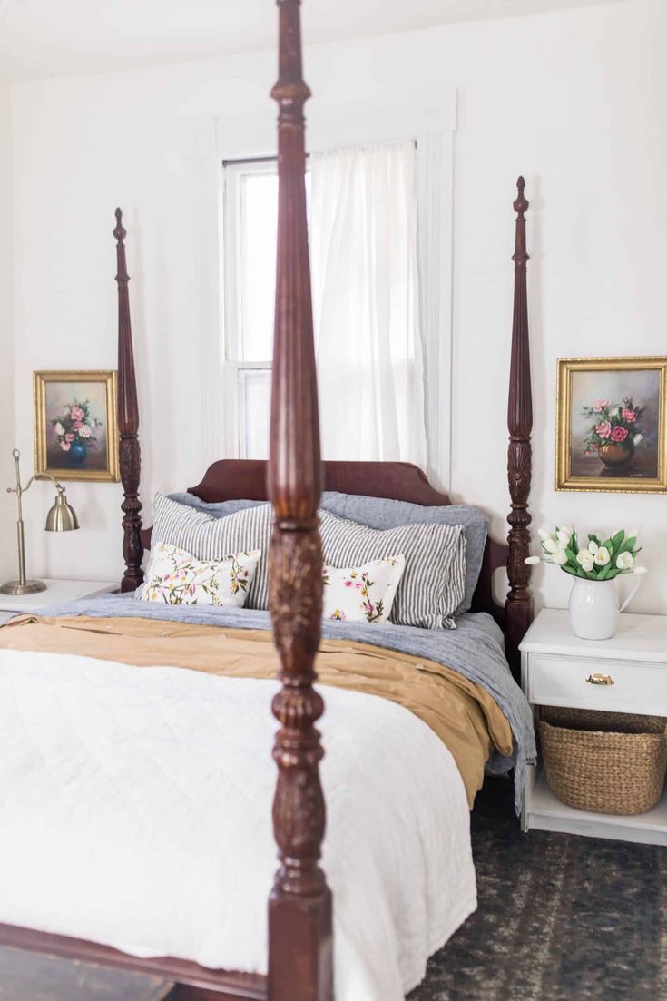 a bedroom with four post bed and white walls