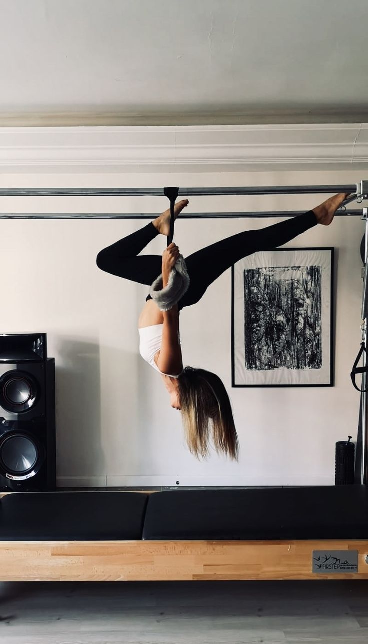 two women doing aerial acrobatic tricks in front of a wall mounted speaker system