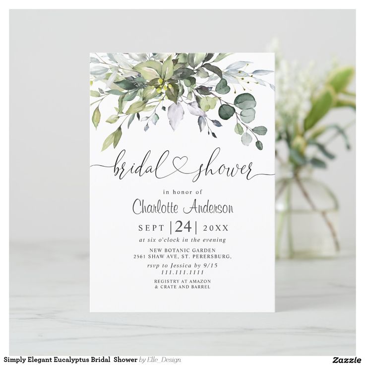 a white wedding card with greenery on it