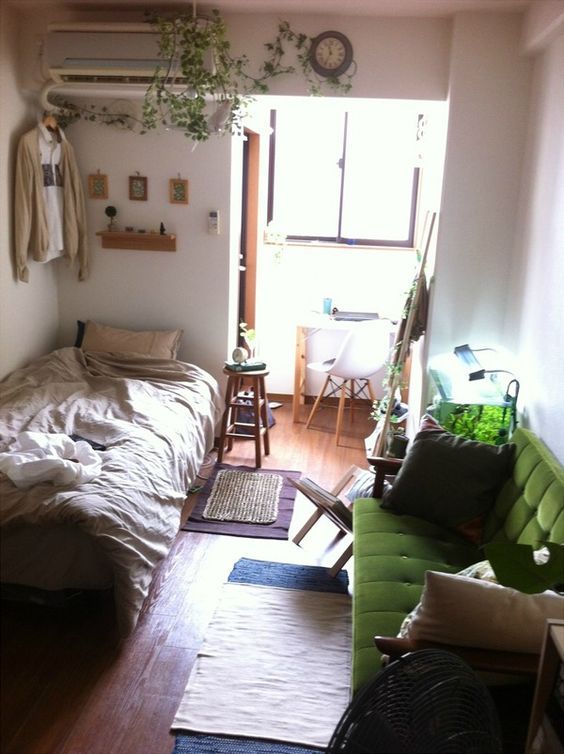 a room with a bed, couch and other items in it on the wooden floor