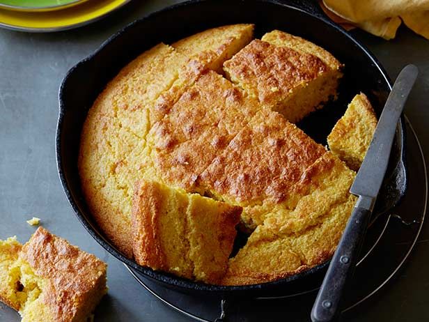 cornbread in a cast iron skillet with two slices cut out on the side