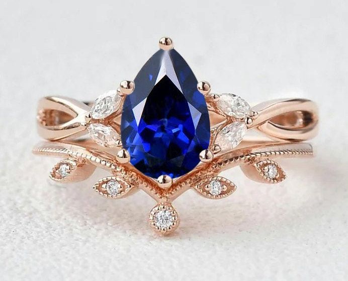 a blue and white diamond ring with leaves on it