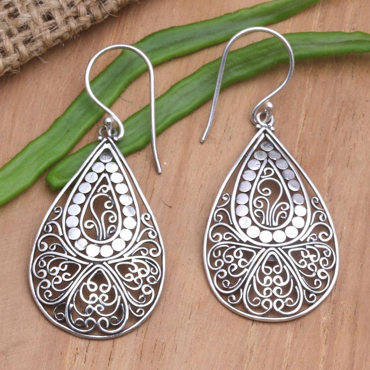 Elaborate silver wirework contrasts with a shimmering dot motif on Kenari's dangle earrings. The Balinese artisan uses sterling silver to create the earrings hand crafting her designs within teardrop frames that dangle from sterling silver hooks. Ornate Sterling Silver Teardrop Earrings For Gift, Ornate Sterling Silver Teardrop Earrings As Gift, Traditional Sterling Silver Teardrop Earrings As Gift, White Teardrop Earrings With Intricate Design, Sterling Silver Intricate Teardrop Earrings, Sterling Silver Teardrop Earrings With Intricate Design, Traditional Handmade Sterling Silver Teardrop Earrings, Traditional Nickel-free Sterling Silver Teardrop Earrings, Ornate Sterling Silver Teardrop Filigree Earrings