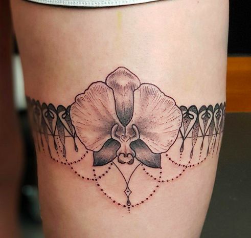 a woman's thigh with a flower tattoo on it