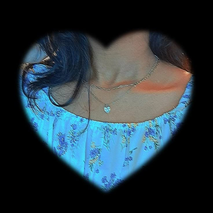 a woman with blue hair wearing a heart shaped necklace