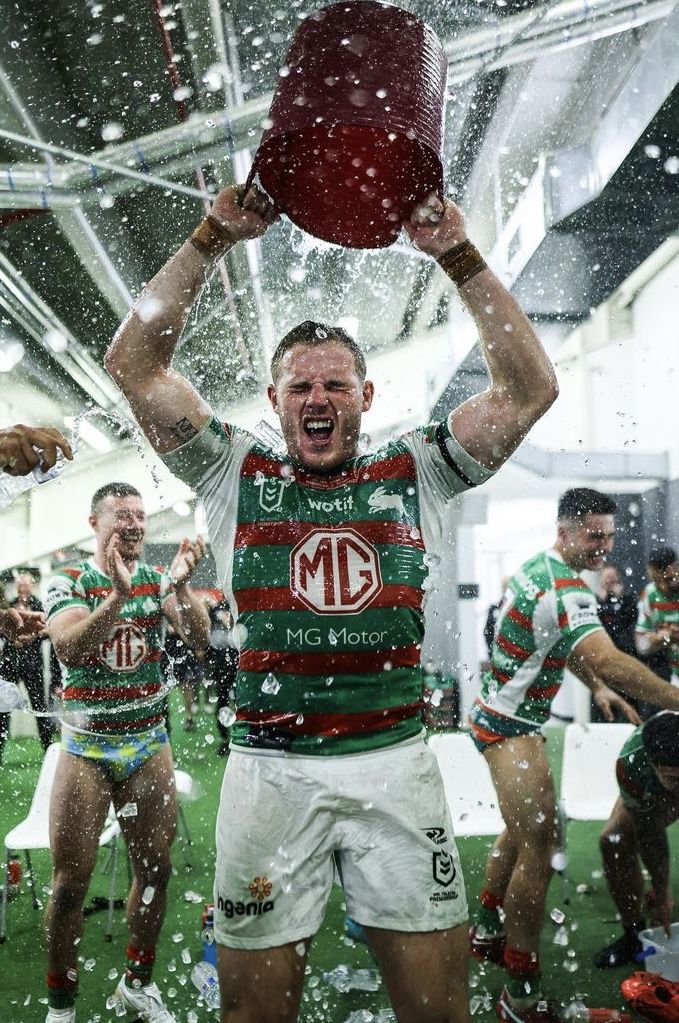 a man holding up a ball in the air while surrounded by other men wearing green and white jerseys