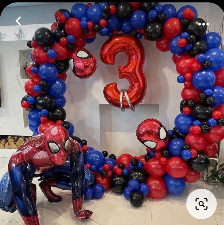 balloons are arranged in the shape of spider - man's head and hands, with other decorations around them