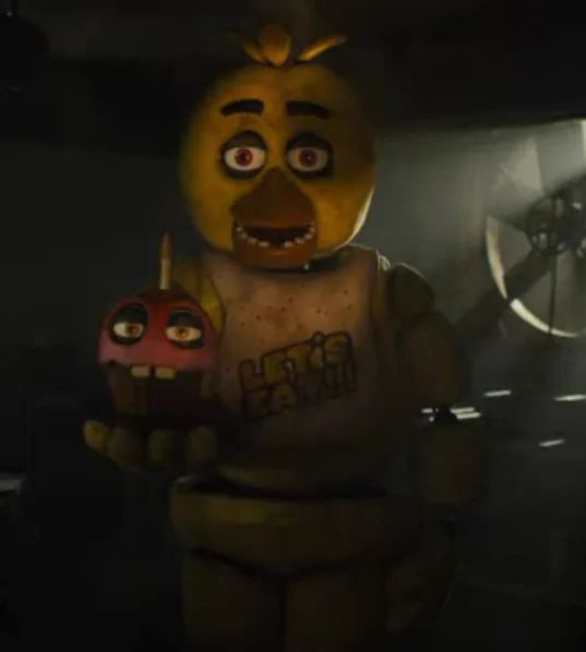 an animated character holding a toy in a dark room