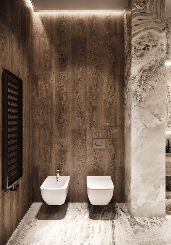 two white toilets sitting next to each other in a room with wooden walls and flooring