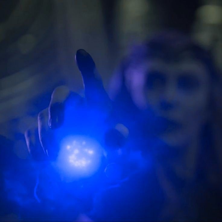 a person holding up their hand with a blue light on it