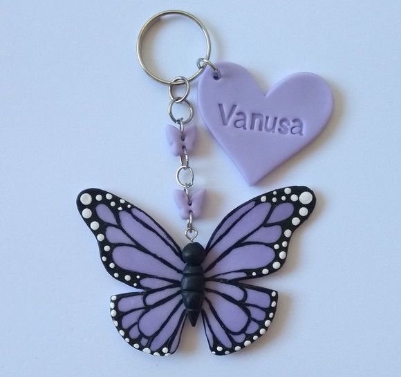 a purple butterfly keychain with a name tag attached to it's side