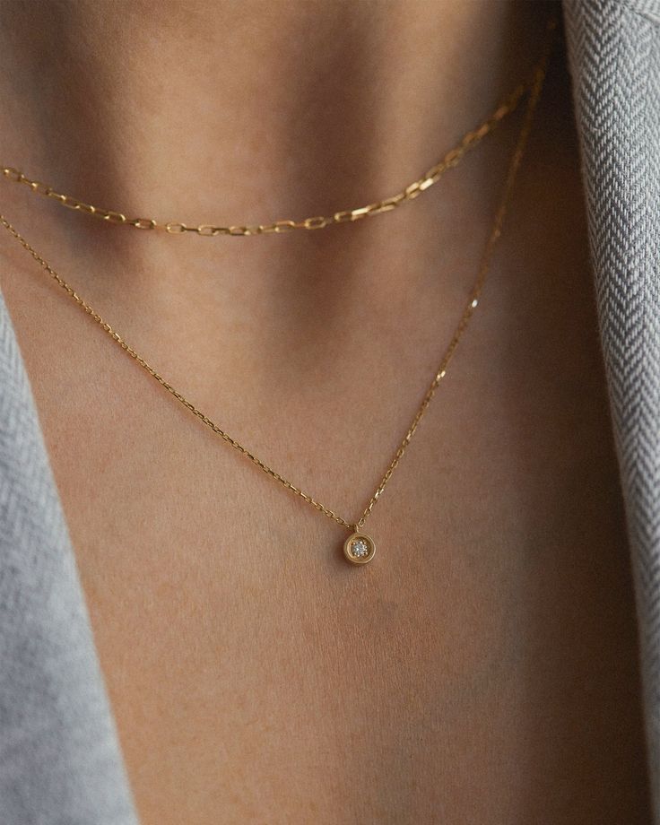 Embrace the beauty of understated elegance with our Minimalist Diamond Necklace. Made of 14k solid gold, this necklace features a captivating 0.03ct diamond in a bezel setting, creating a seamless and refined look. This versatile piece is perfect for both casual and formal occasions. Treat yourself or a loved one with this dainty diamond necklace. Details: * 0.03ct natural white diamond, color F/G, clarity SI1 * 14k solid gold * Chain length: 40cm + 3cm (16" + 1.18") Processing time: The current production time for the necklace is 4-6 weeks.   Packing: All pieces come in a beautiful gift box with a certificate of authenticity, ready for gifting.   Shipping: The free shipping method is by mail including a tracking number, you can upgrade to Express shipping by DHL at checkout. For more info Minimalist Diamond Necklace, Diamond Necklace Gift, Dainty Diamond Necklace, Diamond Solitaire Necklace, Solid Gold Chains, Bezel Set Diamond, Diamond Sizes, Necklace Gift, Diamond Solitaire