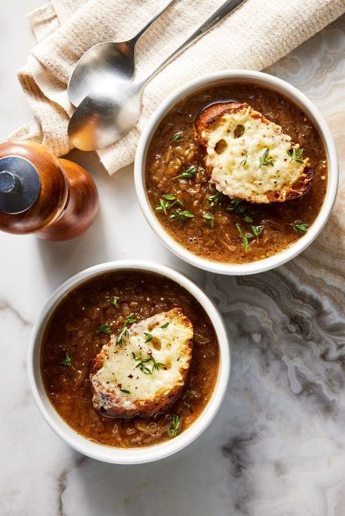 two white bowls filled with soup on top of a table