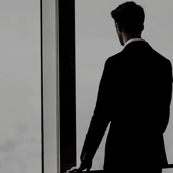 a man in a suit looking out the window