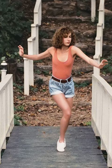 a woman is walking across a bridge with her arms spread out and hands outstretched in the air