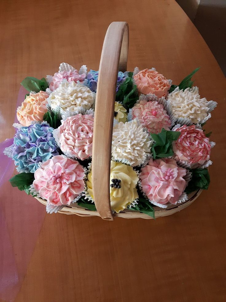 a basket filled with cupcakes sitting on top of a wooden table