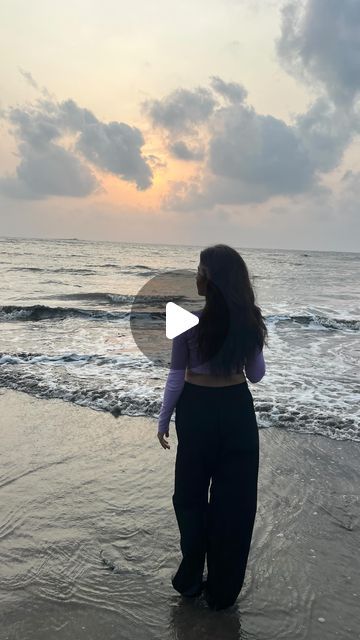 a woman standing on top of a beach next to the ocean