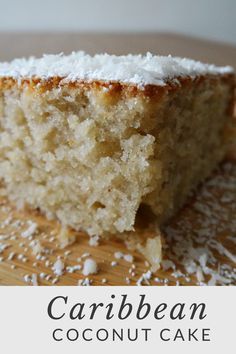 a close up of a piece of cake on a wooden surface with coconut flakes