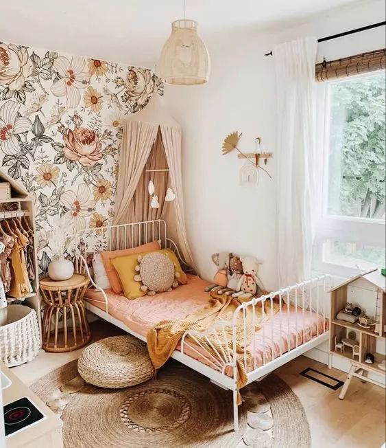 a child's bedroom with floral wallpaper and pink bedding