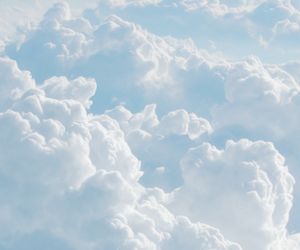 the view from an airplane window shows fluffy clouds