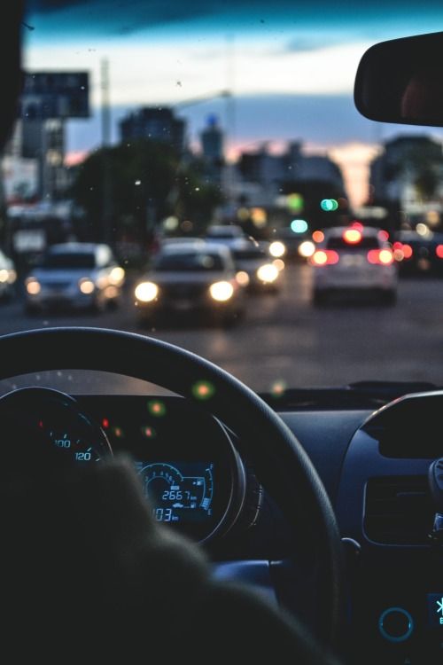 a car driving down a busy city street at dusk